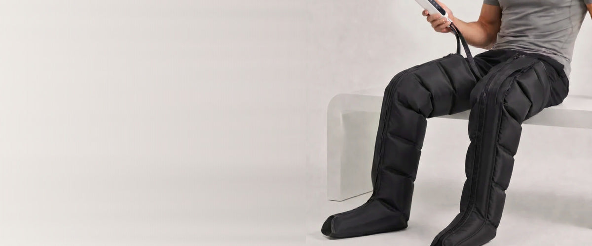 Homme assis portant des bottes de compression Kinessia, télécommande à la main